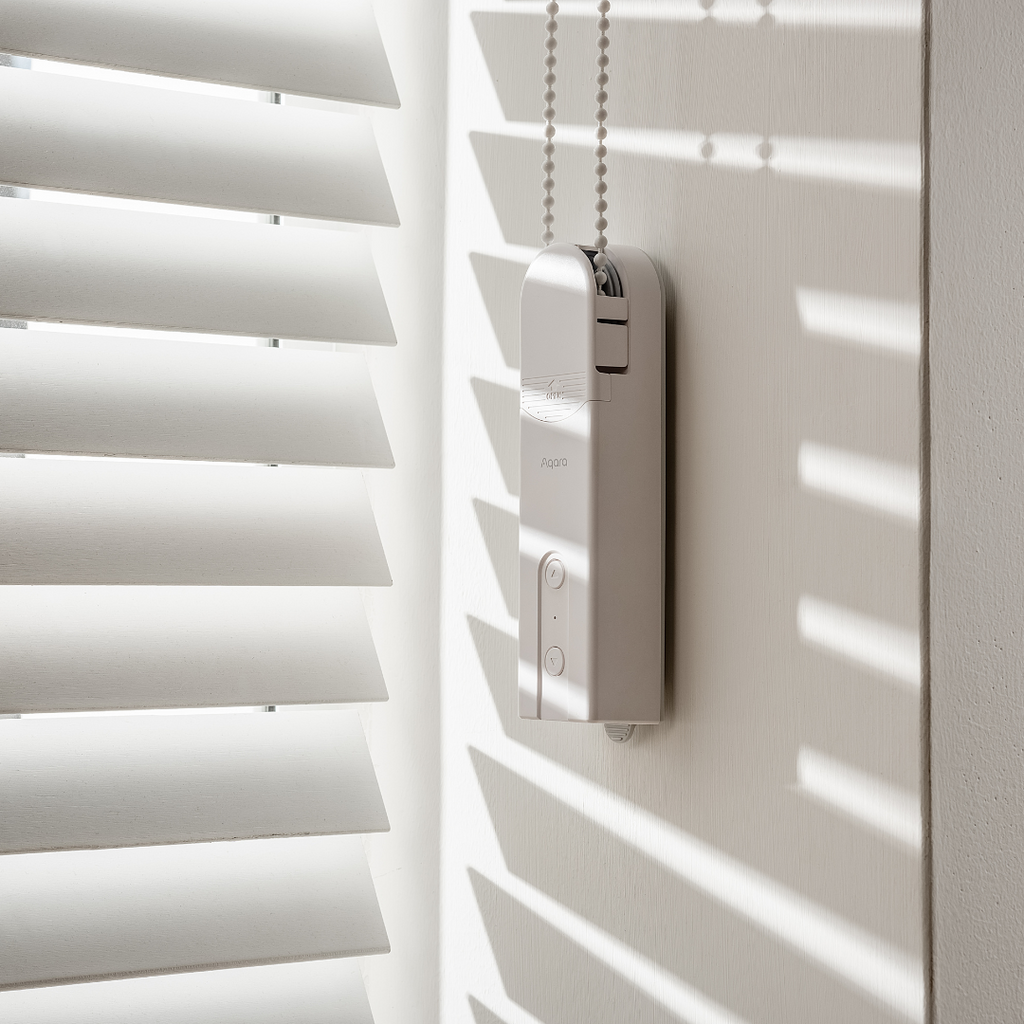 Aqara Roller Shade Driver E1 installed beside a beaded-chain blind – manufacturer reference image