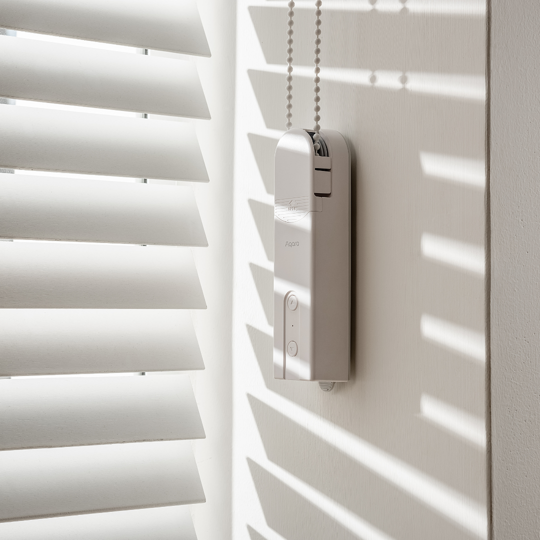 Aqara Roller Shade Driver E1 installed beside a beaded-chain blind – manufacturer reference image